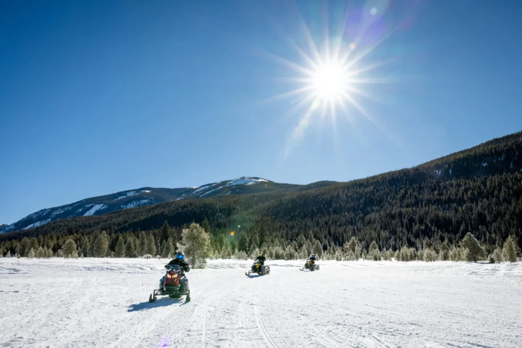 Three riders on a family-friendly Tigiwon guided snowmobile tour at Camp Hale near Vail, Colorado